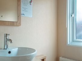 A bathroom with a sink and mirror at Willow in Swanage