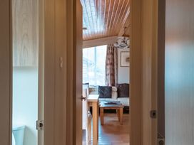 A view into a living room with a table and chairs from a hallway at Willow in Swanage