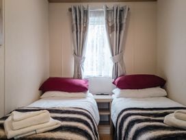A bedroom with two twin beds and a window at Willow in Swanage