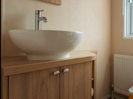 A bathroom with a sink and faucet at Willow in Swanage