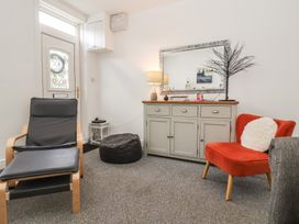 A living room with a chair and a lamp at Bluebell Cottage in Brayton