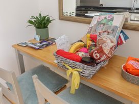 A table with a plant and a basket filled with snacks at Bluebell Cottage in Brayton