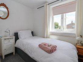 A bedroom with a bed and bedside tables at Bluebell Cottage Brayton
