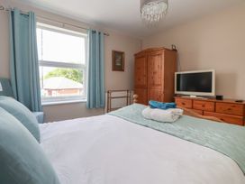 A bedroom with a bed and wardrobe at Bluebell Cottage in Brayton