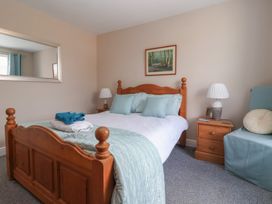 A bedroom with a bed and bedside table at Bluebell Cottage in Brayton