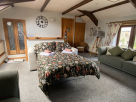 A living room with a sofa bed and chairs at Foxglove Barn South Brent