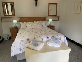 A bedroom with a double bed and bedside tables at Foxglove Barn South Brent