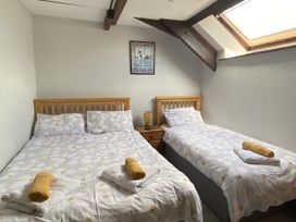 A bedroom with a double bed and a single bed at Foxglove Barn South Brent