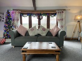 A living room with a sofa and Christmas tree at Foxglove Barn South Brent