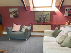 A living room with sofas and wall art at Foxglove Barn South Brent