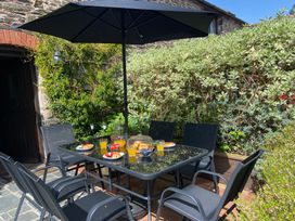 A table with chairs and fruit at an outdoor dining area at Foxglove Barn South Brent