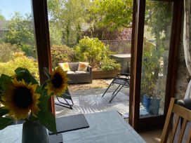 A garden view with sunflowers on a table at Foxglove Barn South Brent