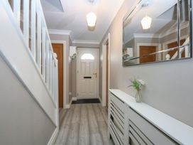 A hallway with a staircase and console table at 2 Trem Y Don in Colwyn Bay