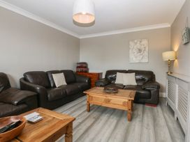 A living room with sofas and a wooden table at 2 Trem Y Don in Colwyn Bay