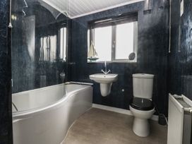 A bathroom with a bathtub, sink, and toilet at 2 Trem Y Don in Colwyn Bay