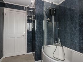 A bathroom featuring a bathtub and shower at 2 Trem Y Don in Colwyn Bay