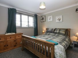 A bedroom with a bed and drawers at 2 Trem Y Don in Colwyn Bay