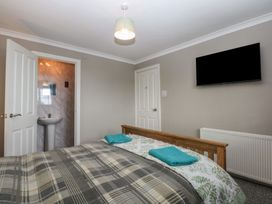 A bedroom with a bed and wall-mounted television at 2 Trem Y Don in Colwyn Bay
