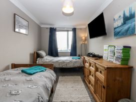 A bedroom with two beds and a dresser at 2 Trem Y Don Colwyn Bay