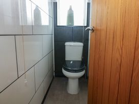 A bathroom with a toilet and a window at 2 Trem Y Don Colwyn Bay