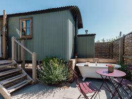 An outdoor area with a bathtub and seating at Hurdlemakers Hut in Piddletrenthide
