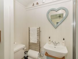 A bathroom with a toilet, sink, and towel rail at Hurdlemakers Hut in Piddletrenthide
