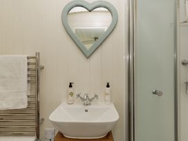 A bathroom with a sink and mirror at Hurdlemakers Hut in Piddletrenthide