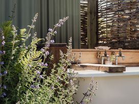 An outdoor area with flowers and a sink at Hurdlemakers Hut in Piddletrenthide