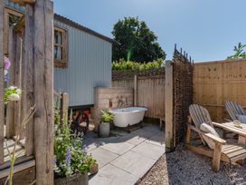 An outdoor area with a bath tub and seating at Spindleberry Hut in Piddletrenthide