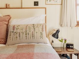 A bedroom with a bed and bedside table at Spindleberry Hut in Piddletrenthide