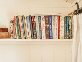 A shelf with books and a wooden box at Spindleberry Hut in Piddletrenthide