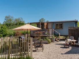 An outdoor seating area with furniture and an umbrella at Spindleberry Hut Piddletrenthide