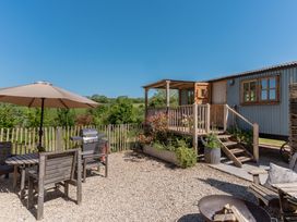 An outdoor area with seating and a barbecue at Spindleberry Hut in Piddletrenthide