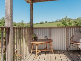 A balcony with a table and chair at Spindleberry Hut in Piddletrenthide