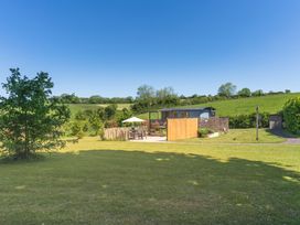 A garden with a fence and seating area at Spindleberry Hut in Piddletrenthide