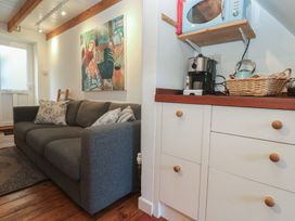 A living room with a sofa and coffee machine at Bodillys Cottage in Newlyn