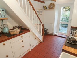 A kitchen with cabinets and a doorway to an outdoor area at Bodillys Cottage Newlyn