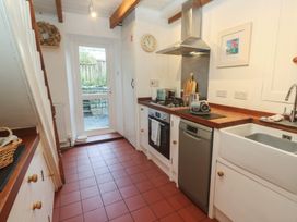 A kitchen with appliances and a door at Bodillys Cottage in Newlyn