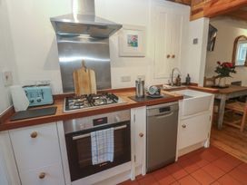 A kitchen with stove, sink, and dishwasher at Bodillys Cottage in Newlyn