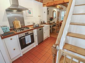 A kitchen with appliances and dining area at Bodillys Cottage Newlyn