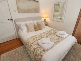 A bedroom with a bed and bedside lamp at Bodillys Cottage in Newlyn
