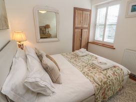 A bedroom with a bed and cupboard at Bodillys Cottage in Newlyn