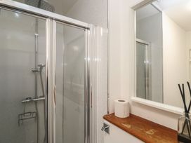 A bathroom with a shower and mirror at Bodillys Cottage in Newlyn