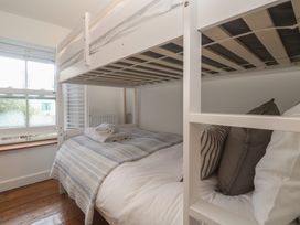 A bunk bed with linens and pillows at Bodillys Cottage Newlyn