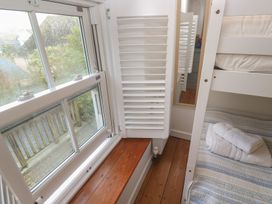 A bedroom with a bunk bed and a window at Bodillys Cottage in Newlyn