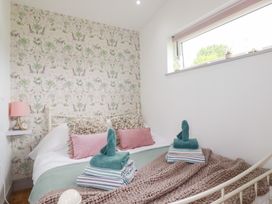 A bedroom with a bed and towels arranged at The Tinystore in Bodmin