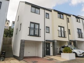 A row of modern three-story houses with garages and cars parked outside at Ocean Retreat in Goodrington near Paignton