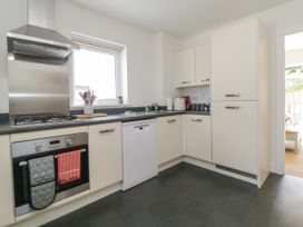 A kitchen with an oven stove dishwasher cabinets and a window at Ocean Retreat in Goodrington near Paignton