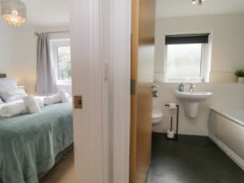 A bedroom with a bed and towels next to a bathroom with a sink and toilet at Ocean Retreat in Goodrington near Paignton
