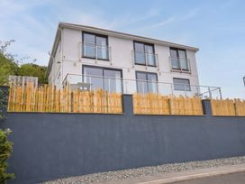 A building with a balcony and fence at Looe Island View in Downderry
